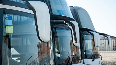 Frontansicht mehrerer geparkter Reisebusse mit großem Panoramafenster – moderne Busflotte bereit zum Einsatz